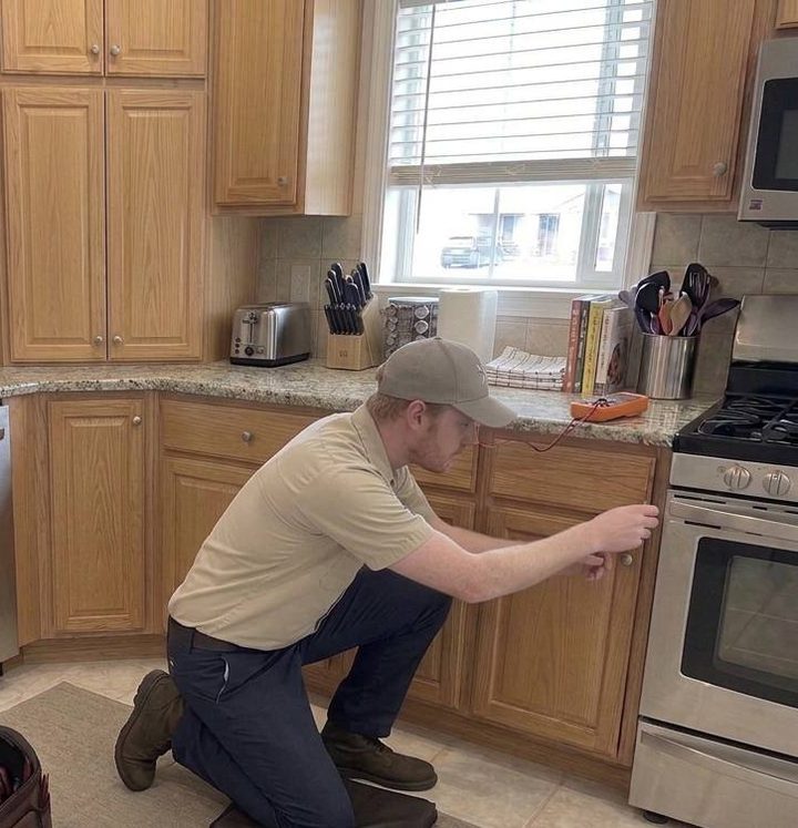 Technician taking readings beside a gas range in a Bellingham kitchen
